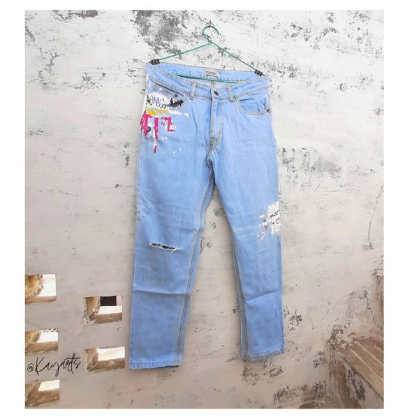 Light blue distressed denim jeans with custom painted artwork and ripped details