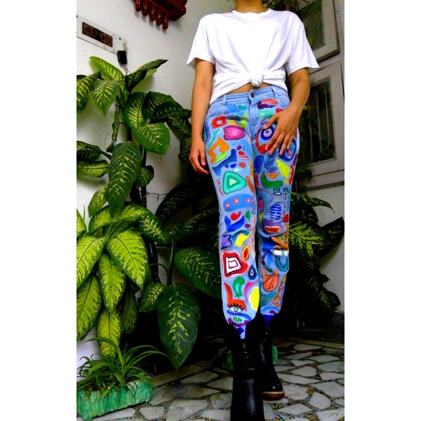 Full view of custom graffiti-painted denim jeans with vibrant multicolor artwork