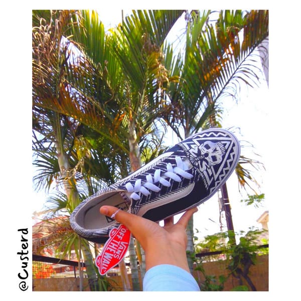 Vans black and white skull custom sneakers angled outdoor